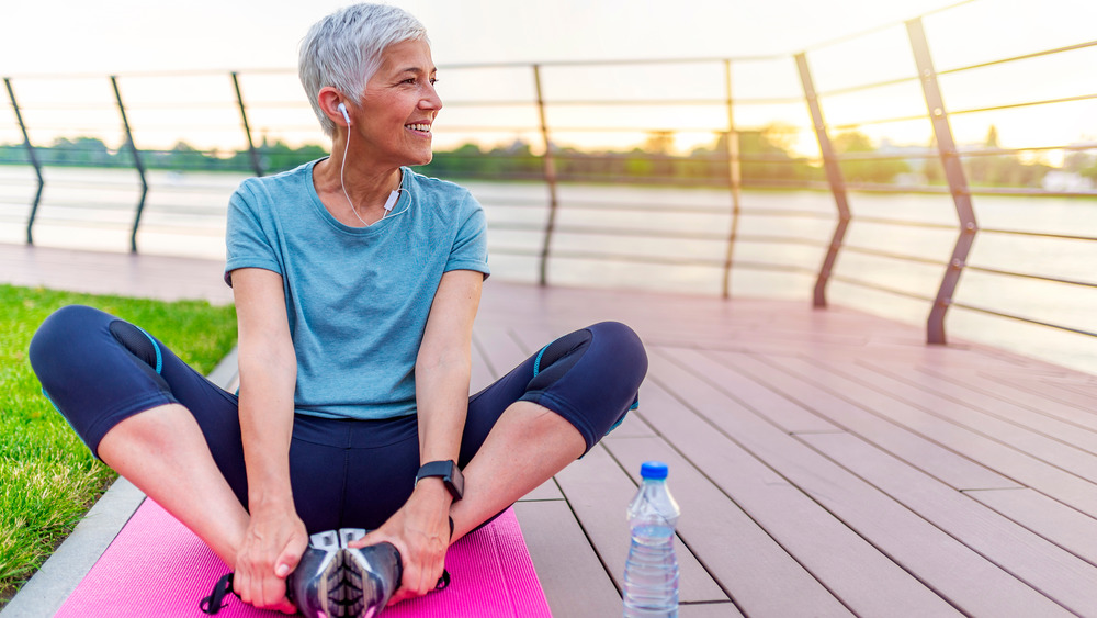 Woman performing a butterfly stretch outside