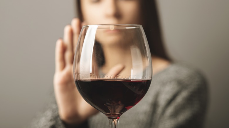 Woman rejecting a glass of red wine