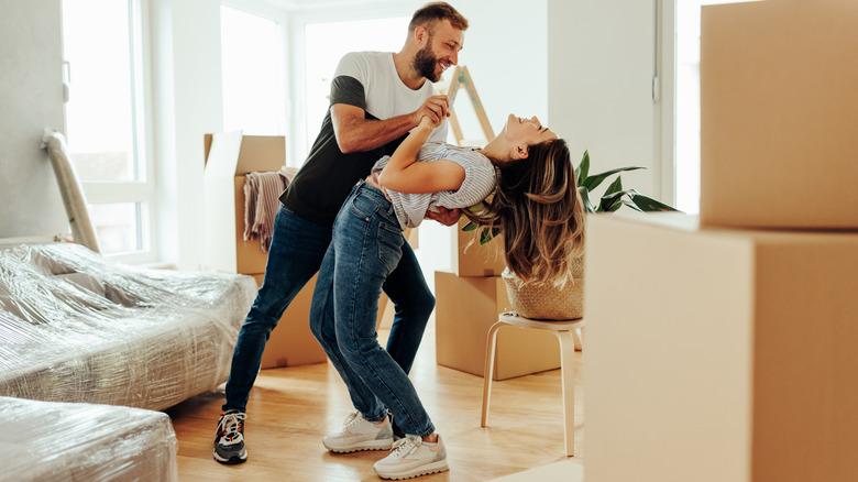 young couple dancing in new home