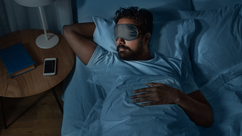 Sleeping man wearing eye mask