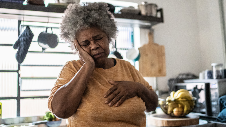 Older woman holding chest