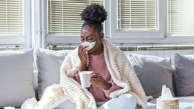 Black woman sick on couch with a cold 