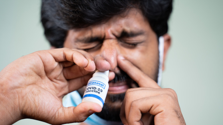 Man using nasal spray for allergies
