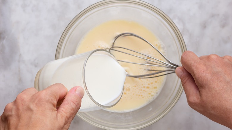 whisking milk into bowl of eggs