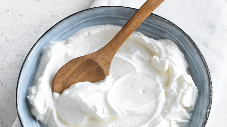 yogurt in bowl with wooden spoon