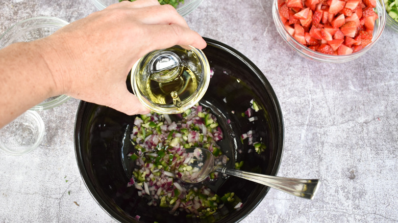 adding oil to chopped veggies