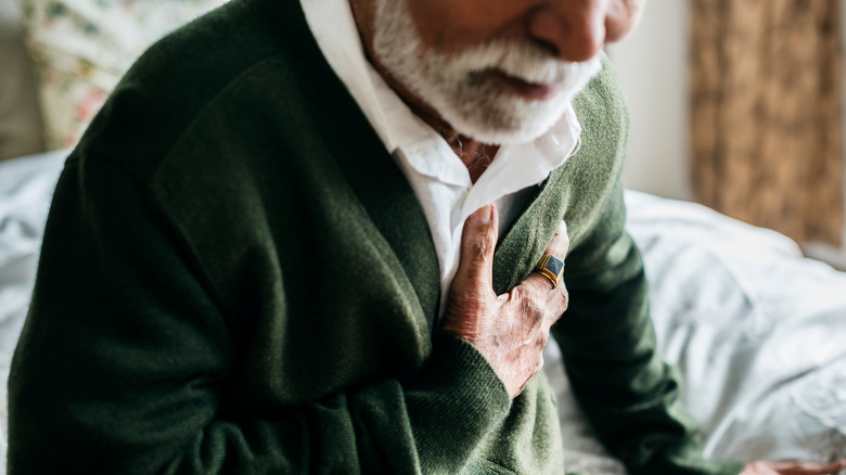 Man in green shirt clutching heart