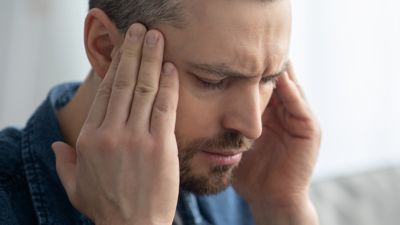 Man with headache touching temples