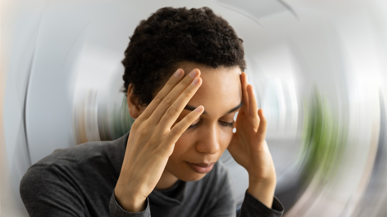 Curly-haired woman experiencing dizziness