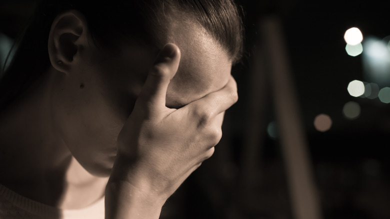 depressed adolescent woman holding head 