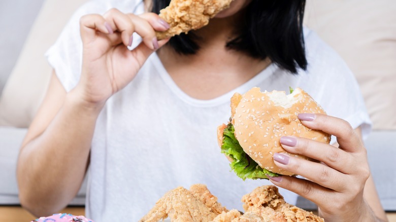 woman binge eating fried chicken