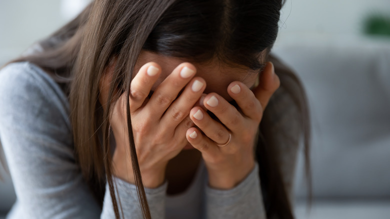 woman hiding face mental health challenge