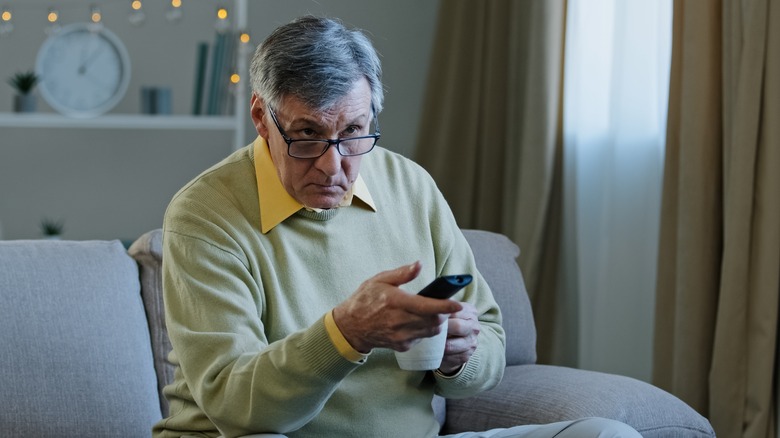 Man sitting on couch holding remote