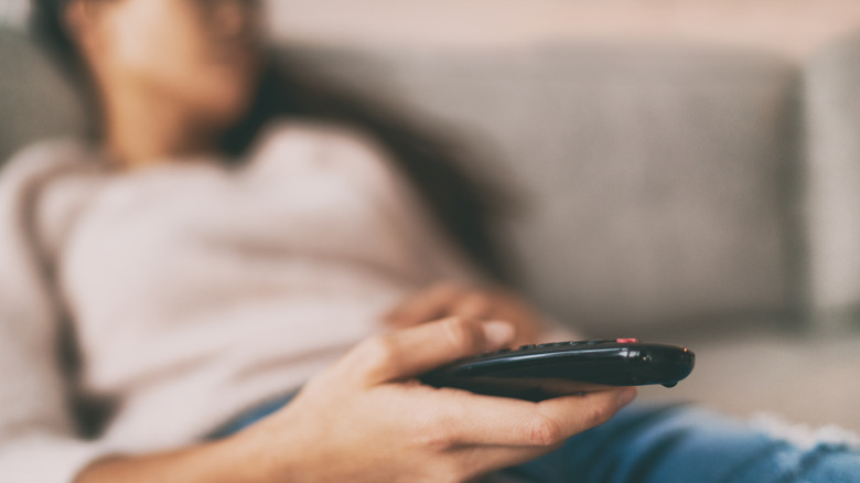 Sleeping person holding TV remote