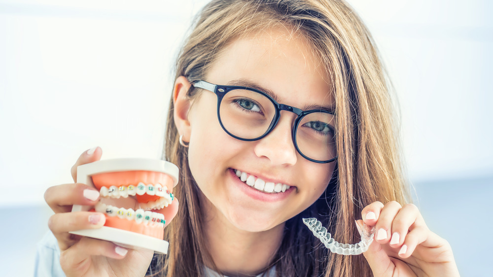 teen girls holding braces, retainer