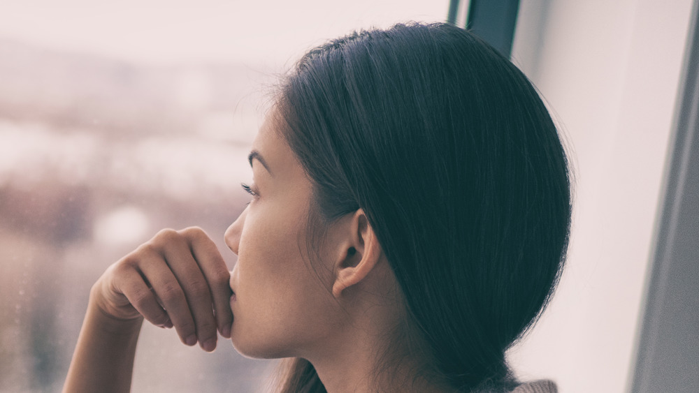 pensive woman staring out a window