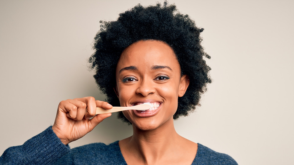 woman lifting her upper lip to show her gum with a pained expression