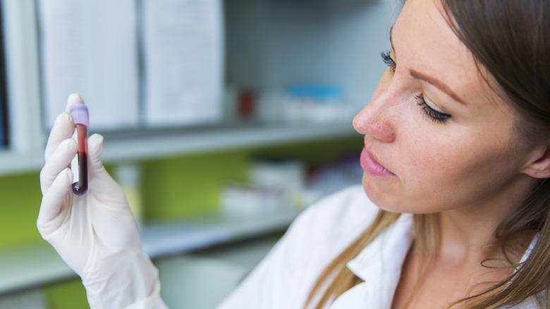 A female healthcare worker holding a blood sample