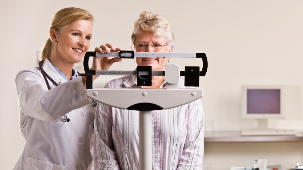 doctor measuring woman's weight