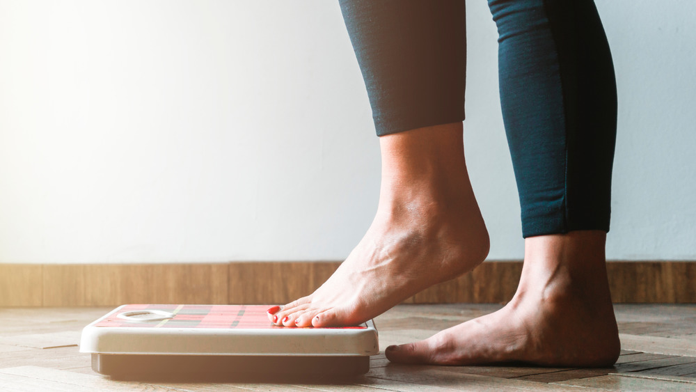 woman stepping onto scale