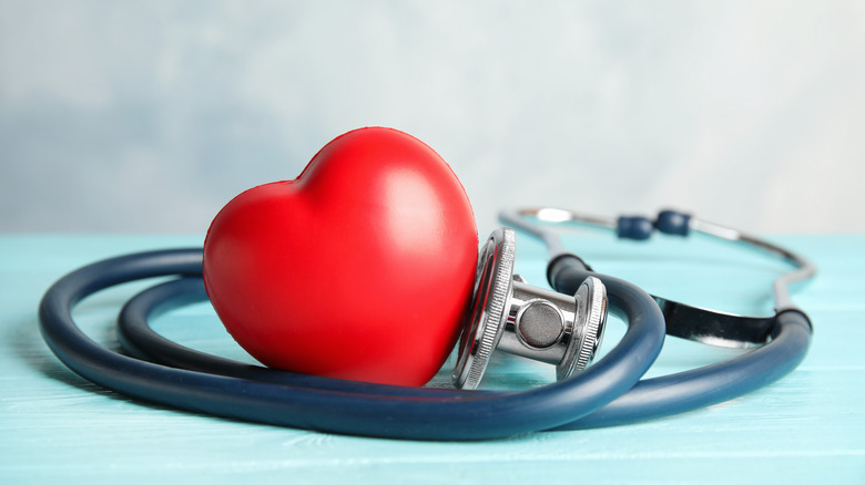 A toy heart sitting next to a doctor's stethoscope