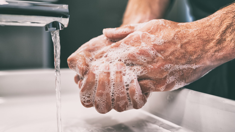 person washing hands in bathroom