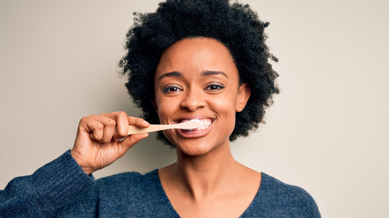 woman brushing teeth with white background