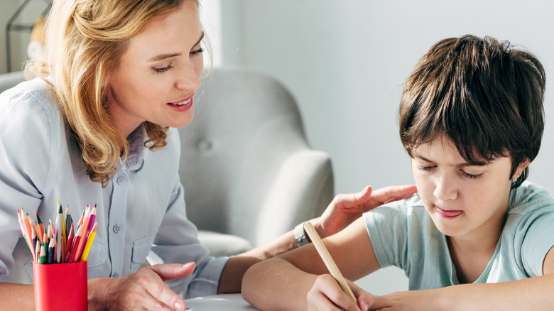 therapist and child with pencil