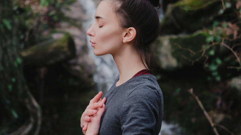 woman doing breathing exercises outdoors 