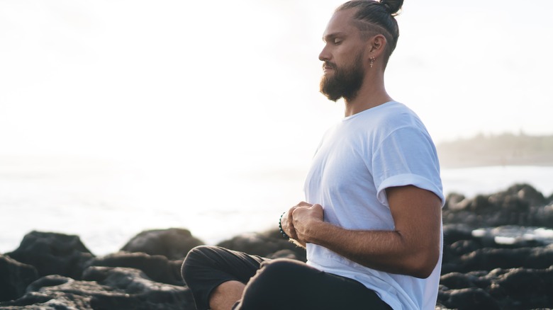 man practicing yoga outdoors