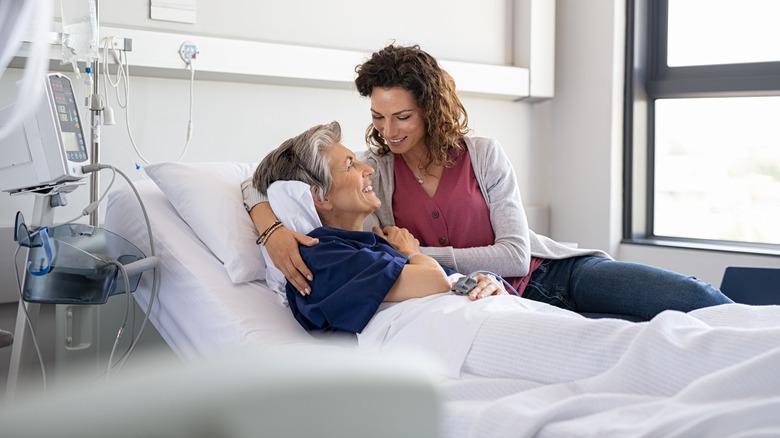 Smiling woman visiting hospitalized patient