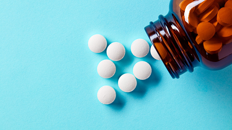 pill bottle spilled over blue background