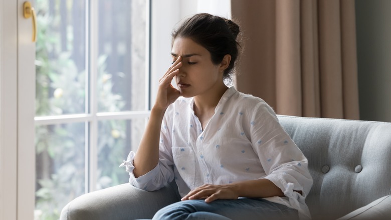 woman on couch with headache