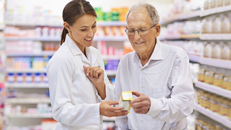 Pharmacist advising elderly man