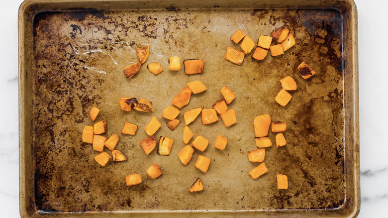 Cooked butternut squash on a baking tray