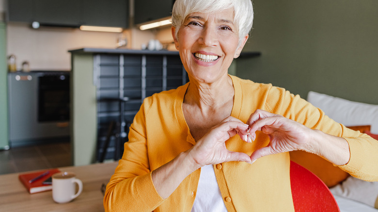 woman holding hands in heart shape