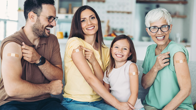 family displaying vaccine bandages