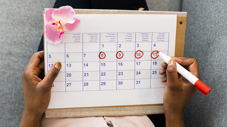 Woman using a calendar to track her menstrual cycle