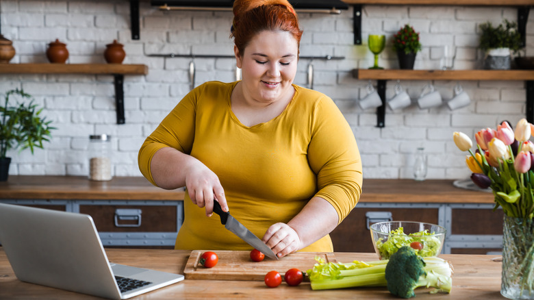 smiling overweight woman making a salad