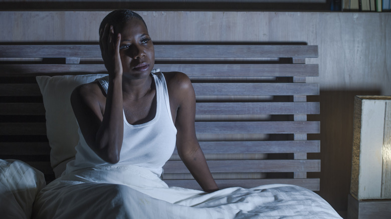 Stressed person sitting up in bed