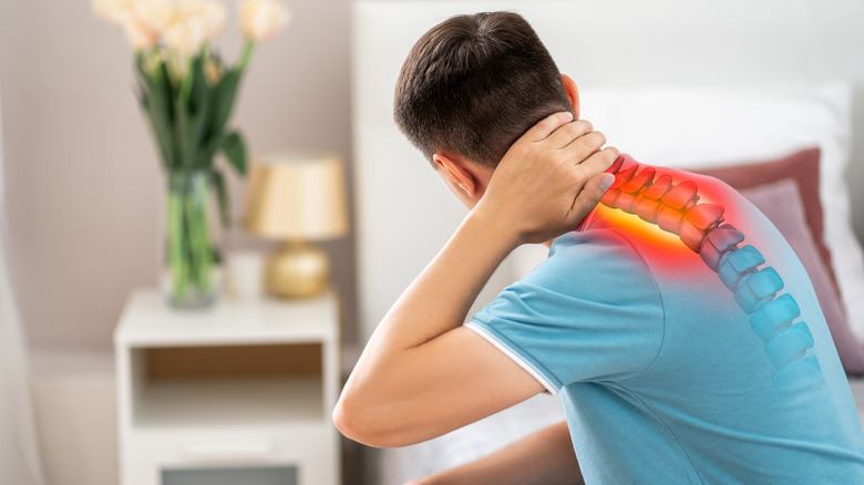 man holding neck with image of spine showing 