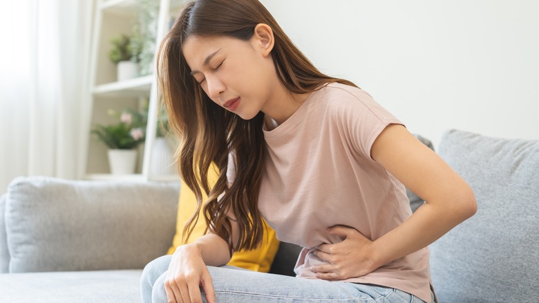 Woman holding stomach in pain