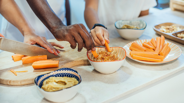 people dipping carrots in hummus