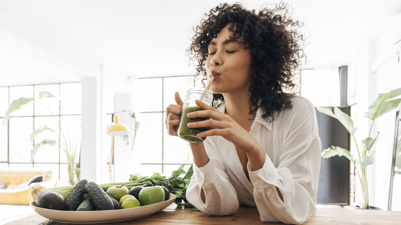 A woman drinking a green juice