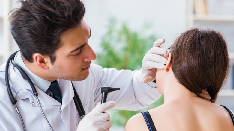 doctor examines girl's ear