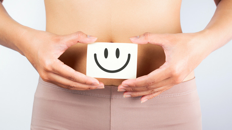 woman holding smile face over stomach