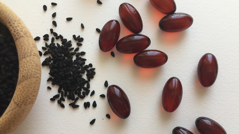 Close up black seeds and gel pills