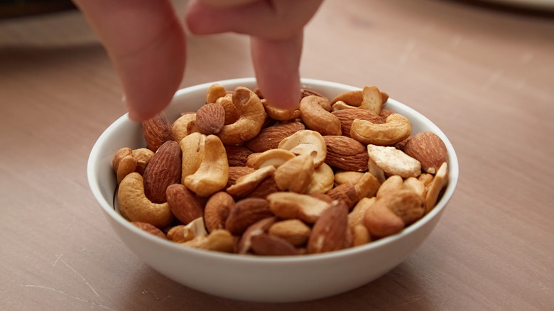 Fingers reaching for cashews