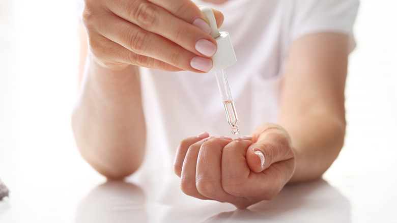 Woman applying oil on nails