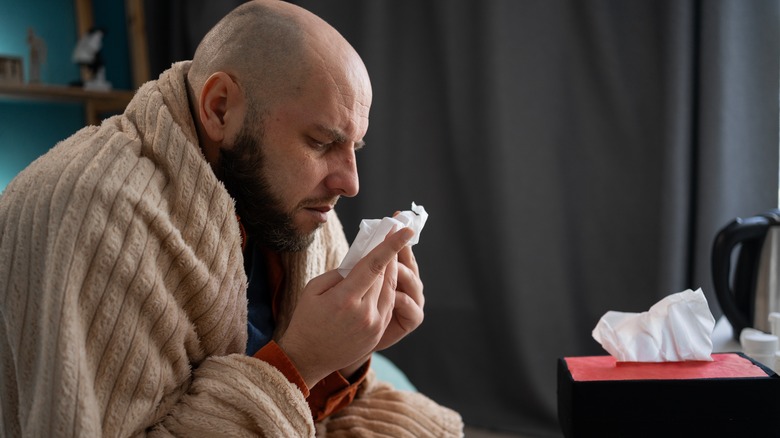 man with stuffy nose wrapped in a blanket